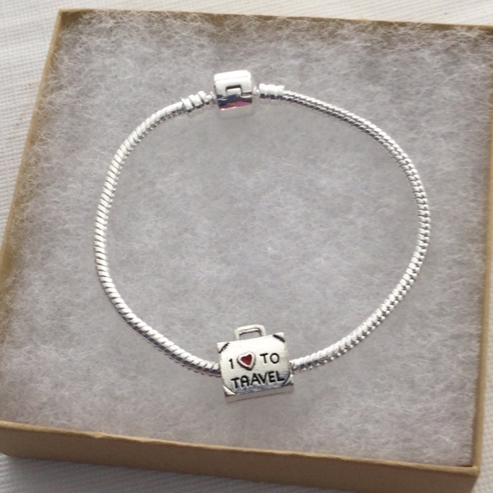 Woman’s Bracelet with one charm that reads I love to travel color sliver.NWOT